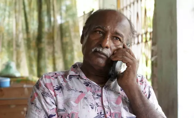 Arobinda Mohalder talks on a phone from his relative's residence after his house was burnt down by a mob, in Dhaka, Bangladesh, Sunday, Aug. 11, 2024. (AP Photo/Al-emrun Garjon)