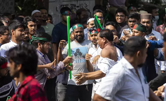 Student protesters rough up a supporter of the ousted Prime Minister Sheikh Hasina's Awami League party suspecting him of paying respect to her father Sheikh Mujibur Rahman on his death anniversary outside his residence in Dhaka, Bangladesh, Thursday, August 15, 2024. (AP Photo/Rajib Dhar)