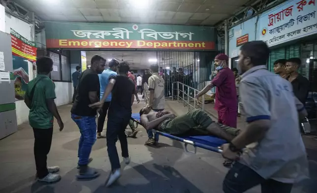 People use a stretcher trolley to carry a man, who was injured during the anti-government protests in Bangladesh, to the emergency ward of a hospital in Dhaka, Bangladesh, Sunday, Aug. 4, 2024. (AP Photo/Rajib Dhar)