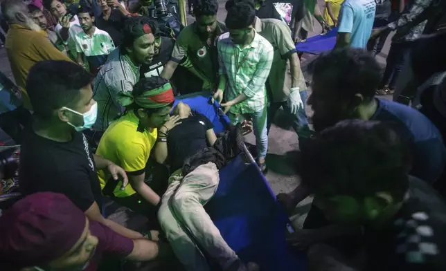 People use a stretcher trolley to carry a woman, who was injured during anti-government protests in Bangladesh, to a hospital in Dhaka, Bangladesh, Sunday, Aug. 4, 2024. (AP Photo/Rajib Dhar)