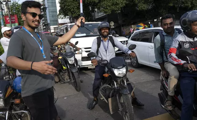 A student volunteer controls traffic, in the absence of traffic policemen on a street in Dhaka, Bangladesh, Tuesday, Aug. 6, 2024. (AP Photo/Fatima Tuj Johora)