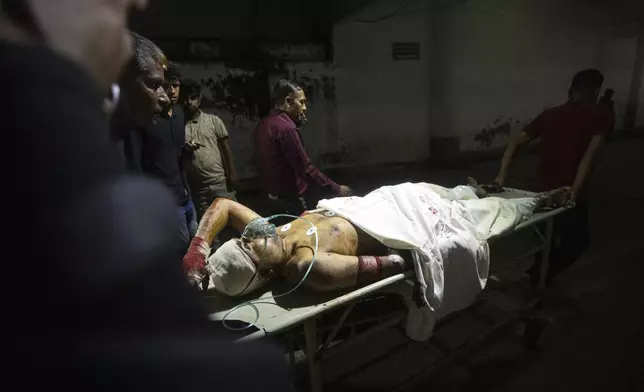 People use a stretcher trolley to carry a man, who was injured during the anti-government protests in Bangladesh, to the emergency ward of a hospital in Dhaka, Bangladesh, Sunday, Aug. 4, 2024. (AP Photo/Rajib Dhar)