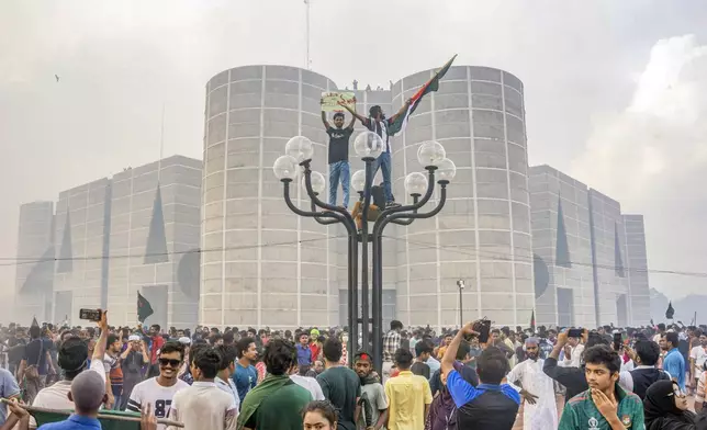 Anti-government protesters celebrate outside the Bangladesh Parliament after getting the news of Prime Minister Sheikh Hasina's resignation, in Dhaka, Bangladesh, Monday, Aug. 5, 2024. (AP Photo/Rajib Dhar)