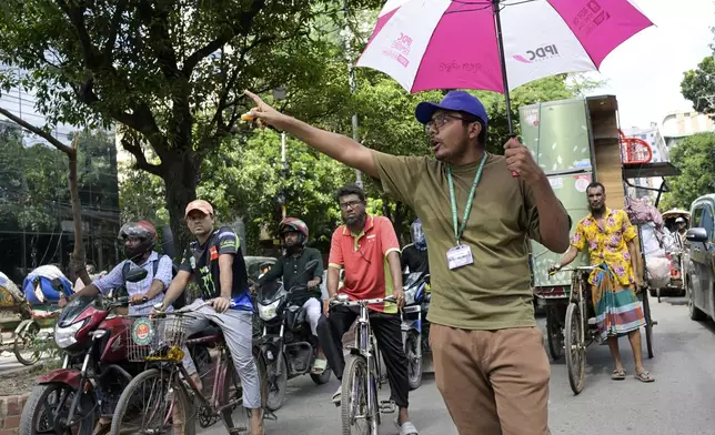 A student volunteer controls traffic, in the absence of traffic policemen on a street in Dhaka, Bangladesh, Wednesday, Aug. 7, 2024. (AP Photo/Fatima Tuj Johora)