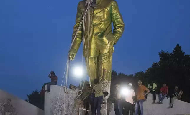 Protesters try to demolish a large statue of Sheikh Mujibur Rahman, father of Bangladesh leader Sheikh Hasina, after she resigned as Prime Minister, in Dhaka, Bangladesh, Monday, Aug. 5, 2024. (AP Photo/Rajib Dhar)