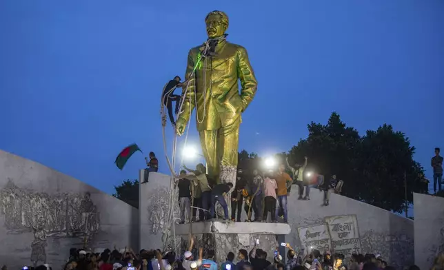 Protesters try to demolish a large statue of Sheikh Mujibur Rahman, father of Bangladesh leader Sheikh Hasina, after she resigned as Prime Minister, in Dhaka, Bangladesh, Monday, Aug. 5, 2024. (AP Photo/Rajib Dhar)