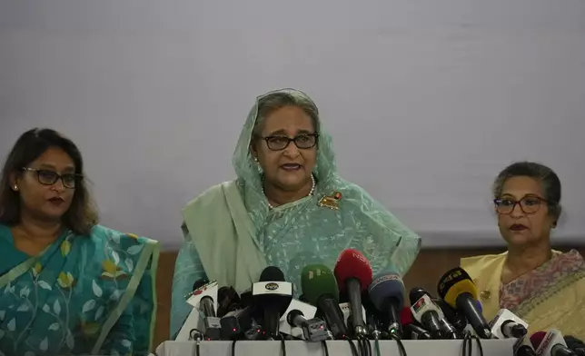 FILE- Bangladesh Prime Minister Sheikh Hasina, centre, is flanked by her daughter Saima Wazed Putul, left, and sister Sheikh Rehana as she speaks to the media after casting her vote in Dhaka, Bangladesh, Sunday, Jan. 7, 2024. Protesters stormed Hasina’s official residence on Monday, Aug. 5, as leader’s whereabouts are unknown. (AP Photo/Altaf Qadri, File)