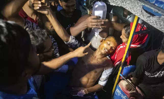 People help a man, who was injured during the anti-government protests in Bangladesh, out of a vehicle at a hospital in Dhaka, Bangladesh, Sunday, Aug. 4, 2024. (AP Photo/Rajib Dhar)