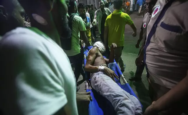 People use a stretcher trolley to carry a man, who was injured during the anti-government protests in Bangladesh, to the emergency ward of a hospital in Dhaka, Bangladesh, Sunday, Aug. 4, 2024. (AP Photo/Rajib Dhar)