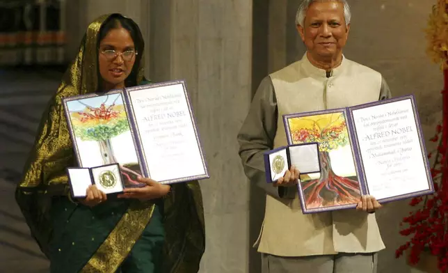 FILE- Nobel Peace Prize winners Muhammad Yunus, right, and Grameen Bank representative Mosammat Taslima Begum display their medals and diplomas at City Hall in Oslo, Norway Sunday Dec. 10, 2006. (AP Photo/John McConnico, File)