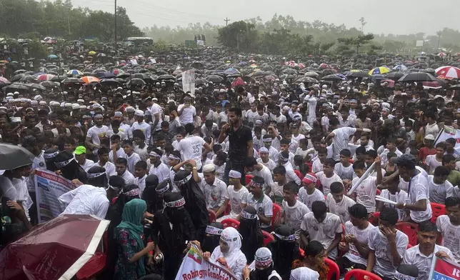 Hundreds of Rohingyas gather in the rain to demand safe return to Myanmar's Rakhine state as they mark the seventh anniversary of their mass exodus from Myanmar at their refugee camp at Kutupalong in Cox's Bazar district, Bangladesh, Sunday, Aug. 25, 2024. (AP Photo/ Shafiqur Rahman)