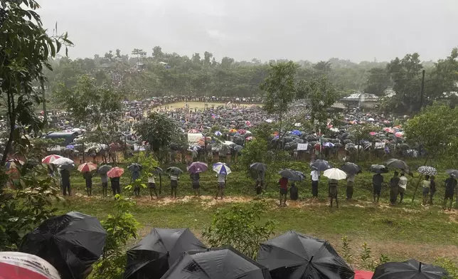 Hundreds of Rohingyas gather in the rain to demand safe return to Myanmar's Rakhine state as they mark the seventh anniversary of their exile from Myanmar at their refugee camp at Kutupalong in Cox's Bazar district, Bangladesh, Sunday, Aug. 25, 2024. (AP Photo/ Shafiqur Rahman)