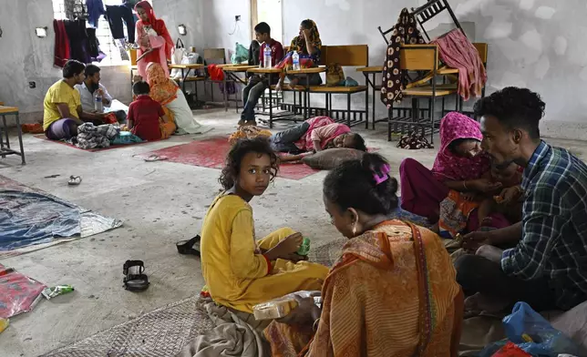 People displaced by floods rest at a relief shelter in Mohipal, Feni, a coastal district in southeast Bangladesh, Friday, Aug. 23, 2024. (AP Photo/Fatima Tuj Johora)