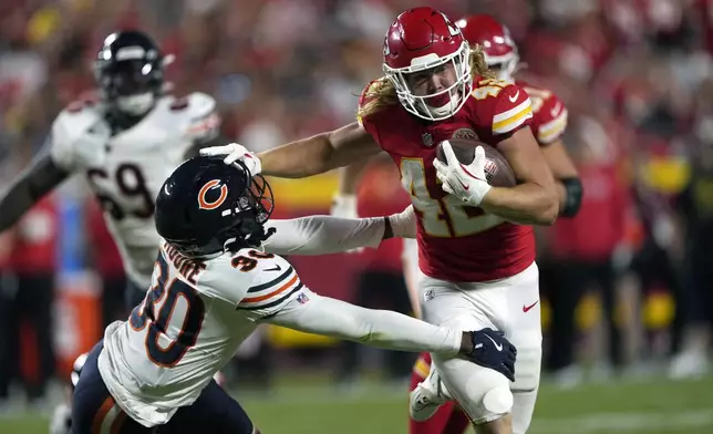 Kansas City Chiefs fullback Carson Steele, right, runs for a 31-yard gain as Chicago Bears defensive back Tarvarius Moore (30) defends during the first half of an NFL preseason football game Thursday, Aug. 22, 2024, in Kansas City, Mo. (AP Photo/Charlie Riedel)