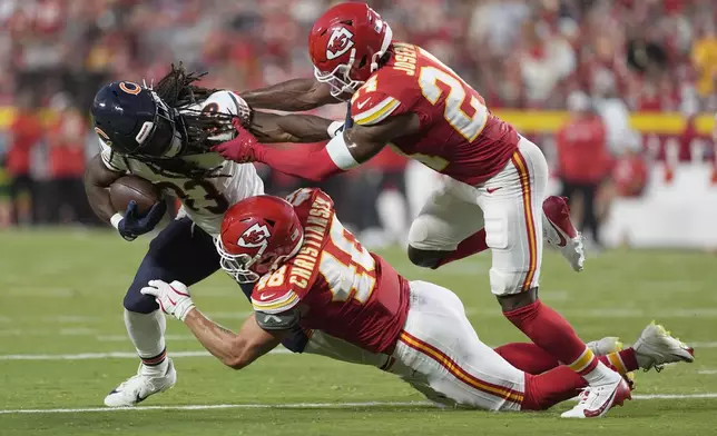 Chicago Bears running back Ian Wheeler, left, struggles for yardage against Kansas City Chiefs linebacker Cole Christiansen (48) and cornerback Kelvin Joseph, right, during the first half of an NFL preseason football game Thursday, Aug. 22, 2024, in Kansas City, Mo. (AP Photo/Charlie Riedel)