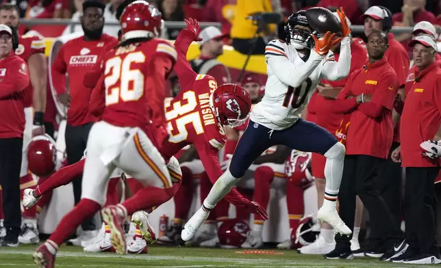 Chicago Bears wide receiver Tyler Scott (10) catches a 37-yard pass as Kansas City Chiefs cornerback Jaylen Watson (35) and safety Deon Bush (26) defend during the first half of an NFL preseason football game Thursday, Aug. 22, 2024, in Kansas City, Mo. (AP Photo/Charlie Riedel)