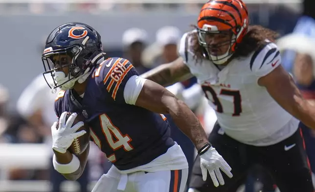 Chicago Bears running back Khalil Herbert (24) runs past Cincinnati Bengals defensive tackle Jay Tufele (97) during the first half of an NFL preseason football game, Saturday, Aug. 17, 2024, at Soldier Field in Chicago. (AP Photo/Erin Hooley)