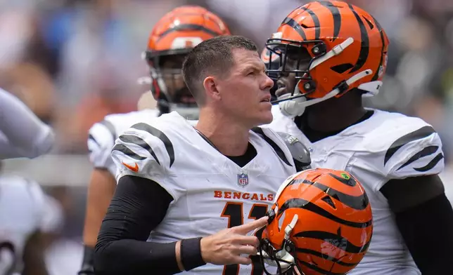 Cincinnati Bengals quarterback Logan Woodside (11) getting up and removes his helmet after he was sacked by Chicago Bears cornerback Kyler Gordon (6) during the first half of an NFL preseason football game, Saturday, Aug. 17, 2024, at Soldier Field in Chicago. (AP Photo/Erin Hooley)