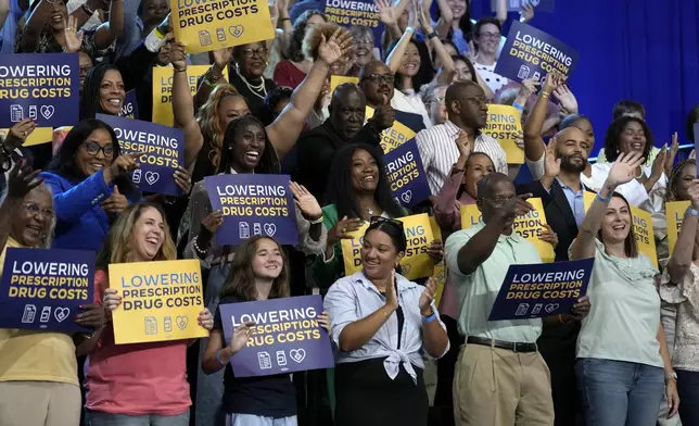 Attendees listen as President Joe Biden and Democratic presidential nominee Vice President Kamala Harris speak about the administration's efforts to lower prescription drug costs during an event at Prince George's Community College in Largo, Md., Thursday, Aug. 15, 2024. (AP Photo/Susan Walsh)