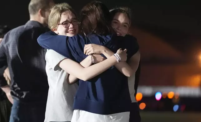 Alsu Kurmasheva, center, hugs her daughters Miriam Butorin, left, and Bibi Butorin at Andrews Air Force Base, Md., following her release as part of a 24-person prisoner swap between Russia and the United States, Thursday, Aug. 1, 2024. (AP Photo/Alex Brandon)