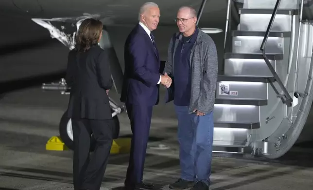 President Joe Biden, center, and Vice President Kamala Harris, left, greet Paul Whelan, right, at Andrews Air Force Base, Md., following their release as part of a 24-person prisoner swap between Russia and the United States, Thursday, Aug. 1, 2024. (AP Photo/Manuel Balce Ceneta)