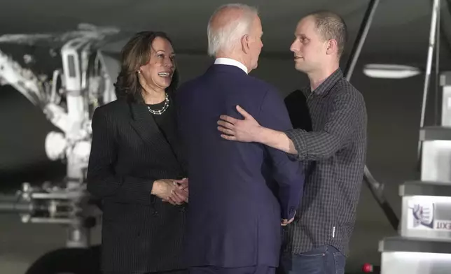 President Joe Biden and Vice President Kamala Harris greet reporter Evan Gershkovich at Andrews Air Force Base, Md., following his release as part of a 24-person prisoner swap between Russia and the United States, Thursday, Aug. 1, 2024. (AP Photo/Manuel Balce Ceneta)