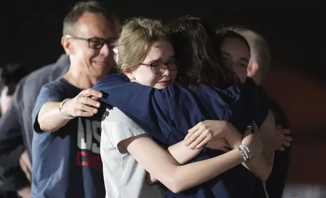 Alsu Kurmasheva, second right, hugs her husband Pavel Butorin, from left, and daughters Miriam Butorin and Bibi Butorin at Andrews Air Force Base, Md., following her release as part of a 24-person prisoner swap between Russia and the United States, Thursday, Aug. 1, 2024. (AP Photo/Alex Brandon)