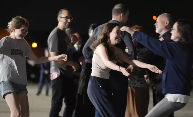 Miriam Butorin, from left, and Bibi Butorin, daughters of Alsu Kurmasheva, run to hug their mother at Andrews Air Force Base, Md., following her release as part of a 24-person prisoner swap between Russia and the United States, Thursday, Aug. 1, 2024. (AP Photo/Alex Brandon)