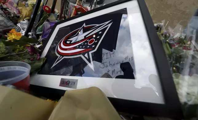 Keepsakes are left at a memorial set up by fans for Blue Jackets hockey player Johnny Gaudreau in Columbus, Ohio, Aug. 30, 2024. Gaudreau, along with his brother Matthew, was fatally struck by a motorist while riding his bicycle on Thursday. (AP Photo/Joe Maiorana)