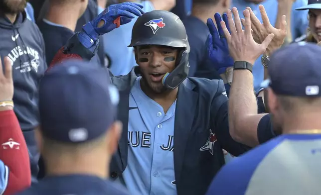 Toronto Blue Jays' Leo Jimenez is greeted in the dugout after hitting two-run home run during the third inning of a baseball game against the Los Angeles Angels, Monday, Aug. 12, 2024, in Anaheim, Calif. (AP Photo/Jayne-Kamin-Oncea)