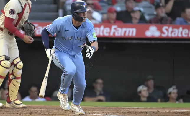 Toronto Blue Jays' Will Wagner, right, runs to first after hitting an RBI single during the third inning of a baseball game against the Los Angeles Angels Monday, Aug. 12, 2024, in Anaheim, Calif. (AP Photo/Jayne-Kamin-Oncea)