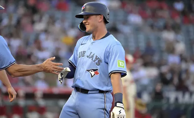 Toronto Blue Jays' Will Wagner, right reacts at first base after hitting an RBI single during the third inning of a baseball game against the Los Angeles Angels, Monday, Aug. 12, 2024, in Anaheim, Calif. (AP Photo/Jayne-Kamin-Oncea)