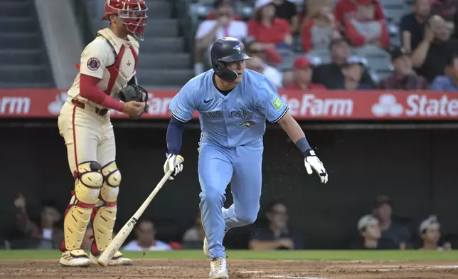 Toronto Blue Jays' Will Wagner, right, runs to first after hitting an RBI single during the third inning of a baseball game against the Los Angeles Angels, Monday, Aug. 12, 2024, in Anaheim, Calif. (AP Photo/Jayne-Kamin-Oncea)