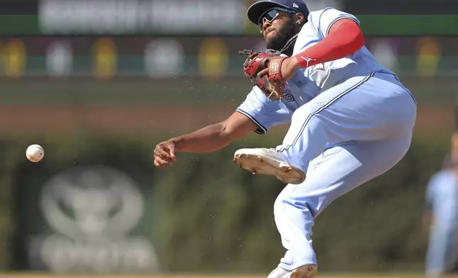 Toronto Blue Jays' Vladimir Guerrero Jr. falls as he throws out Chicago Cubs' Miguel Amaya at first base during the eighth inning of a baseball game Sunday, Aug. 18, 2024, in Chicago. (AP Photo/Melissa Tamez)