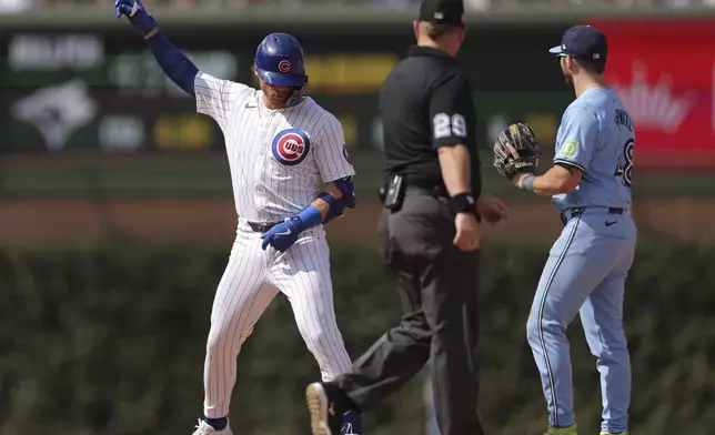 Chicago Cubs' Nico Hoerner, left, reacts after hitting a double during the seventh inning of a baseball game against the Toronto Blue Jays, Sunday, Aug. 18, 2024, in Chicago. (AP Photo/Melissa Tamez)