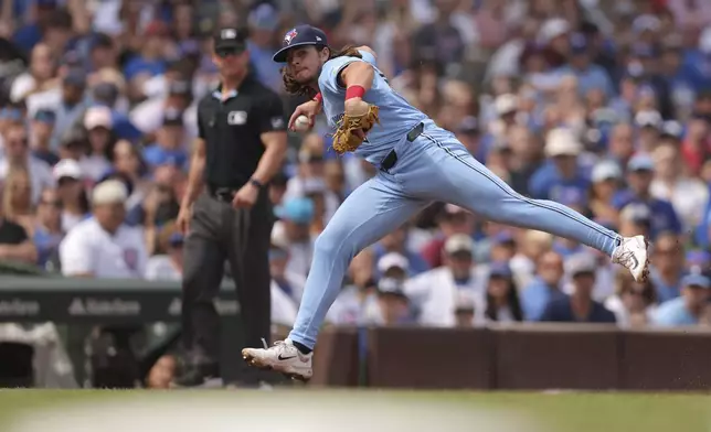 Toronto Blue Jays' Addison Barger, right, throws to first base during the fifth inning of a baseball game against the Chicago Cubs, Sunday, Aug. 18, 2024, in Chicago. (AP Photo/Melissa Tamez)