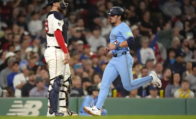 Toronto Blue Jays' Addison Barger, right, scores in front of Boston Red Sox catcher Danny Jansen, left, on a one-run double by Ernie Clement in the sixth inning of a baseball game, Thursday, Aug. 29, 2024, in Boston. (AP Photo/Steven Senne)