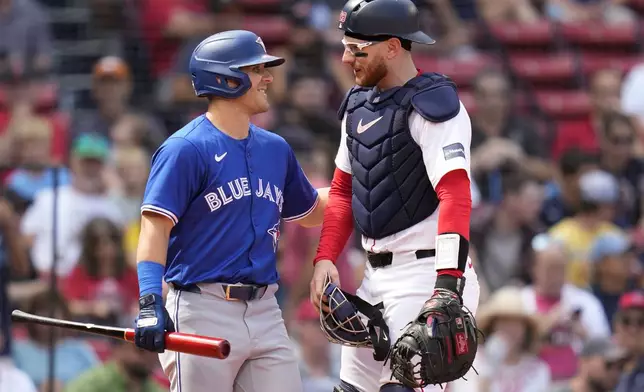 Boston Red Sox catcher Danny Jansen, right, gets a pat on the back from Toronto Blue Jays Daulton Varsho, who pinch-hit for Jansen, during the resumption of the second inning of a baseball game which was delayed due to rain in June, against the Toronto Blue Jays at Fenway Park, Monday, Aug. 26, 2024, in Boston. (AP Photo/Charles Krupa)