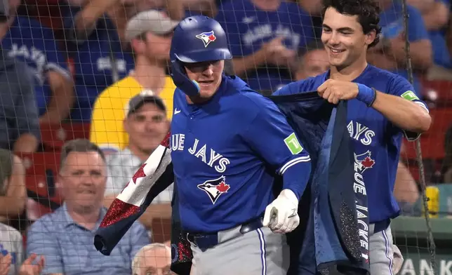 Toronto Blue Jays' Will Wagner is congratulated by Joey Loperfido, right, after hitting a solo home run during the sixth inning of a baseball game against the Boston Red Sox at Fenway Park, Tuesday, Aug. 27, 2024, in Boston. (AP Photo/Charles Krupa)