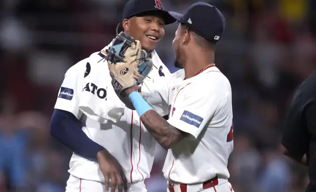 Boston Red Sox pitcher Brayan Bello, left, is congratulated by Ceddanne Rafaela after defeating the Toronto Blue Jays 3-0 following a baseball game at Fenway Park, Wednesday, Aug. 28, 2024, in Boston. (AP Photo/Charles Krupa)