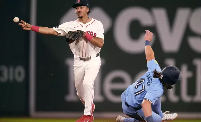 Boston Red Sox shortstop David Hamilton, left, forces out Toronto Blue Jays' Addison Barger on a double play ball hit by Alejandro Kirk during the fifth inning of a baseball game at Fenway Park, Wednesday, Aug. 28, 2024, in Boston. (AP Photo/Charles Krupa)