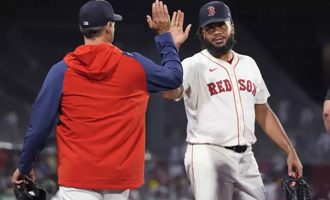 Boston Red Sox pitcher Kenley Jansen is congratulated by pitcher Rich Hill, left, after defeating the Toronto Blue Jays in a baseball game at Fenway Park, Tuesday, Aug. 27, 2024, in Boston. (AP Photo/Charles Krupa)