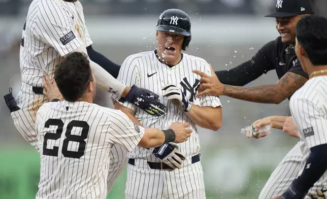 Teammates celebrate with New York Yankees' DJ LeMahieu, center, after he hit a walkoff RBI single during the 10th inning of a baseball game against the Toronto Blue Jays at Yankee Stadium, Sunday, Aug. 4, 2024, in New York. (AP Photo/Seth Wenig)