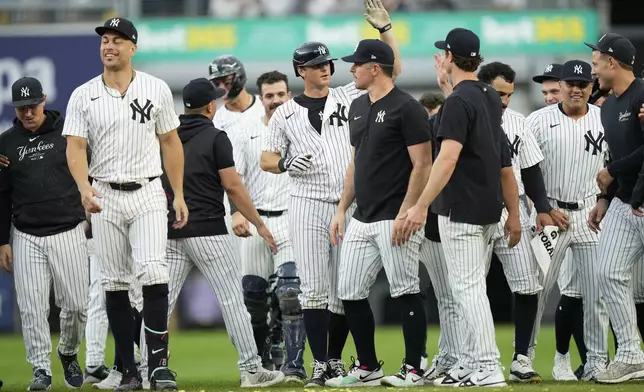 New York Yankees' DJ LeMahieu, center, celebrates with teammates after hitting a walkoff RBI single during the 10th inning of a baseball game against the Toronto Blue Jays at Yankee Stadium, Sunday, Aug. 4, 2024, in New York. (AP Photo/Seth Wenig)