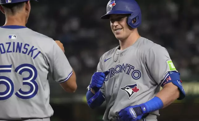 Toronto Blue Jays' Brian Serven, right, celebrates with Toronto Blue Jays first base coach Mark Budzinski, left, after hitting a single which led to Spencer Horwitz and Davis Schneider scoring during the third inning of a baseball game against the New York Yankees, Friday, Aug. 2, 2024, in New York. (AP Photo/Pamela Smith)