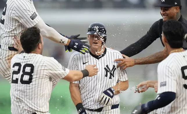 Teammates celebrate with New York Yankees' DJ LeMahieu, center, after he hit a walkoff RBI single during the 10th inning of a baseball game against the Toronto Blue Jays at Yankee Stadium, Sunday, Aug. 4, 2024, in New York. (AP Photo/Seth Wenig)