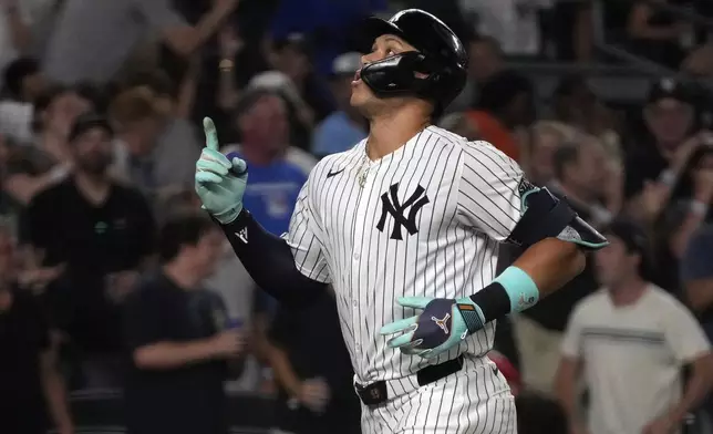 New York Yankees' Aaron Judge celebrates after hitting a home run which also scored Juan Soto during the first inning of a baseball game against the Toronto Blue Jays, Friday, Aug. 2, 2024, in New York. (AP Photo/Pamela Smith)