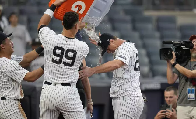 Teammates dump water on New York Yankees' DJ LeMahieu after he hit a walk-off RBI single during the tenth inning of a baseball game against the Toronto Blue Jays at Yankee Stadium, Sunday, Aug. 4, 2024, in New York. (AP Photo/Seth Wenig)