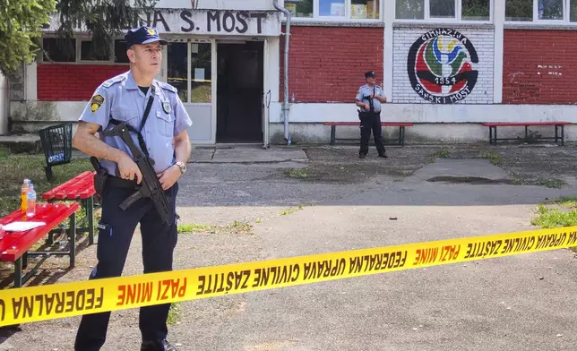 Police officers stand in front of a secondary school building in Sanski Most, northwest of Bosnia's capital, Sarajevo, Wednesday, Aug. 21, 2024, after a school employee shot and killed three people. (AP Photo/Edvin Zulic)