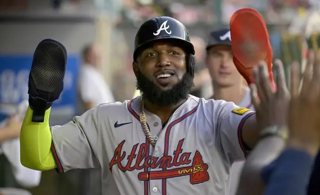 Atlanta Braves' Marcell Ozuna is congratulated in the dugout after scoring in the fourth inning of a baseball game against the Los Angeles Angels, Friday, Aug. 16, 2024, in Anaheim, Calif. (AP Photo/Jayne Kamin-Oncea)